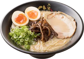 写真：白濁したスープに細切りのキクラゲ、大きなチャーシューが1枚、小口切りのネギ、縦半分に切った煮卵1個がトッピングされたラーメン